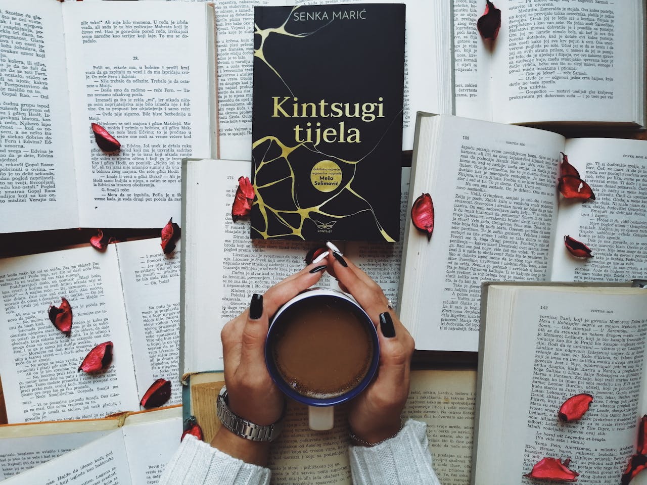 A serene scene featuring a book, cup of coffee, and scattered rose petals, perfect for relaxation themes.